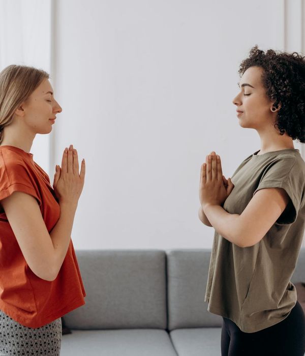 Woman practicing a calm yoga pose in a softly lit room.